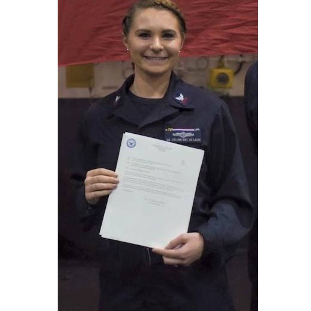 Courtney Mais holding an award in uniform